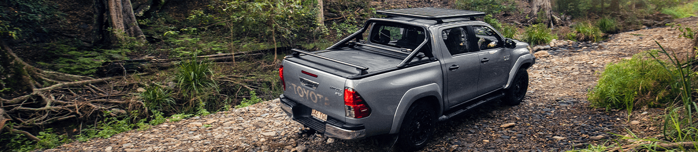 a ute driving through a dirt road in the scrub